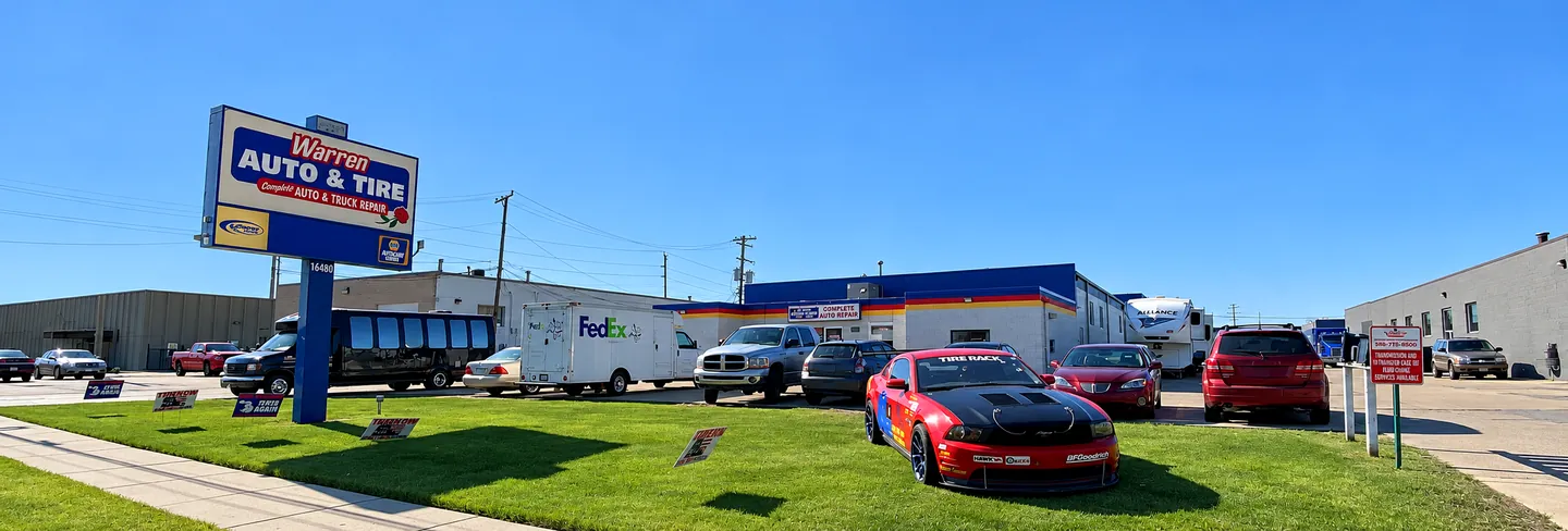 Warren Auto & Tire on 13 Mile Road: the roadside sign, the shop and customers’ vehicles in the lot